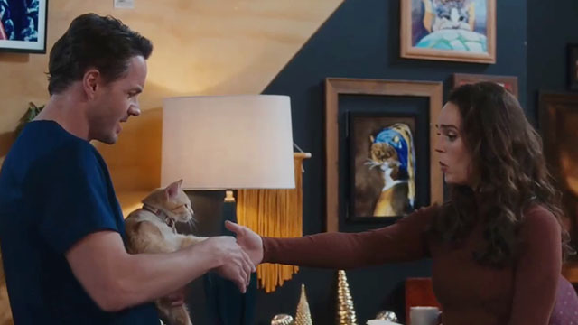 Christmas at the Catnip Cafe - Ben Paul Campbell holding ginger and white cat Holly who shakes hands with Olivia Erin Cahill