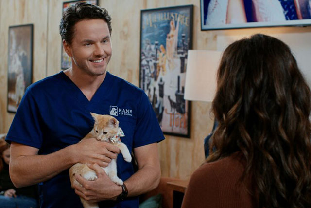 Christmas at the Catnip Cafe - Ben Paul Campbell holding ginger and white cat Holly with Olivia Erin Cahill
