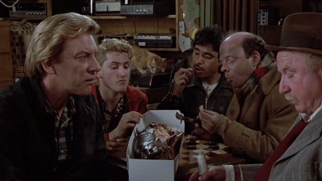 Crackers - orange tabby cat in background behind cast Donald Sutherland Sean Penn Wallace Shawn