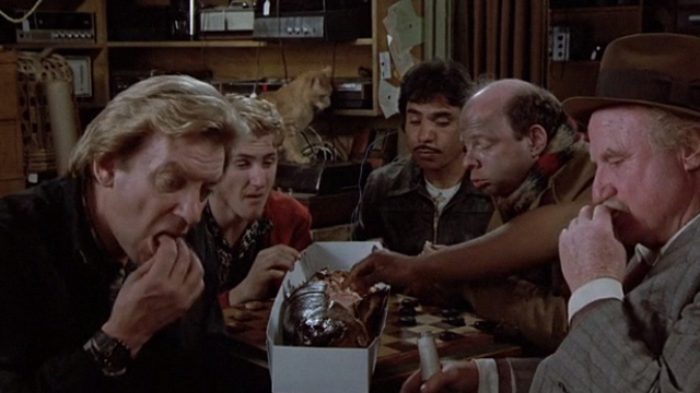 Crackers - orange tabby cat in background behind cast Donald Sutherland Sean Penn Wallace Shawn