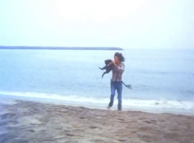 The Cremators - hippie Mason Caulfield running on beach with black cat