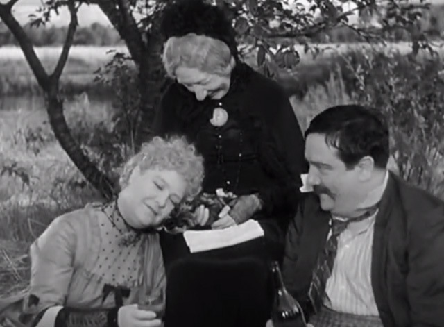 A Day in the Country - grandmother Gabrielle Fontan sitting and holding tabby kitten at picnic with Madame Dufour Jane Marken leaning in