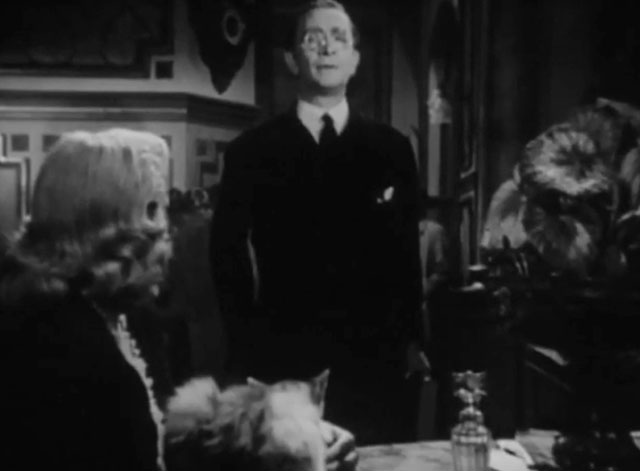 Death Walks in the Rain - La muerte camina en la lluvia - longhair tabby cat sitting on table next to Valeria Duval Margarita Corona