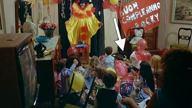Delitto sull'autostrada - Crime on the Highway - Nico Tomas Milian dressed as clown at birthday party with tuxedo cat Filiberto ducking under cabinet