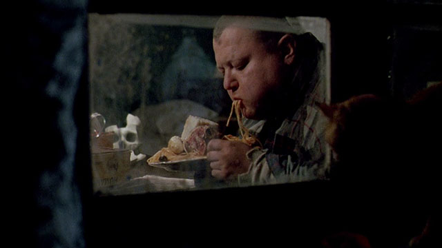 Dellamorte Dellamore - Gnaghi François Hadji-Lazaro eating in window with ginger tabby cat outside