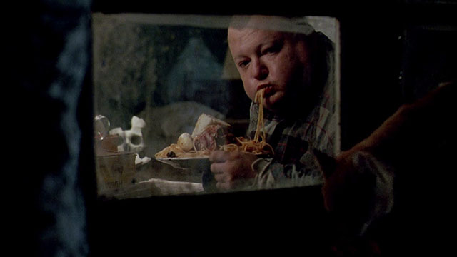 Dellamorte Dellamore - Gnaghi François Hadji-Lazaro eating in window with ginger tabby cat outside