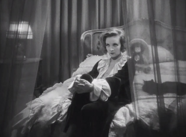 Dishonored - long-haired black cat Blackie on bed beside Marie Marlene Dietrich