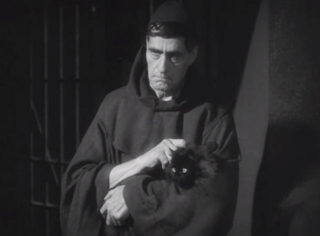 Dishonored - long-haired black cat Blackie being held by priest