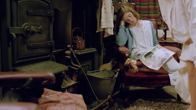The Dressmaker - black cat sitting by fire with Rita Jane Horrocks