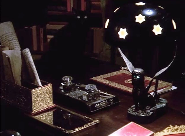 Dr. Strange - longhair black cat with green eyes on desk