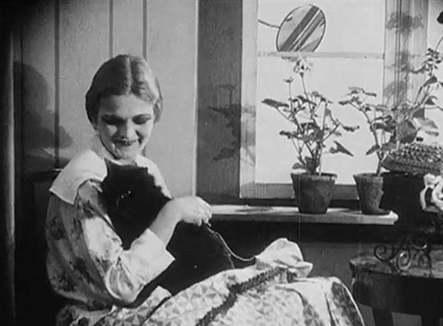 Eerie Tales - Unheimliche Geschichten - Anita Berber holding black cat while sewing