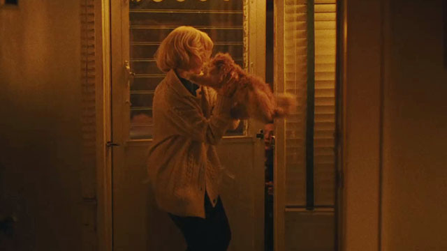 Eileen - Rebecca Anne Hathaway holding cream colored Selkirk Rex Persian cat at doorway