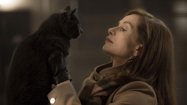 Elle - Mich&egrave;le Isabelle Huppert holding up gray cat Marty