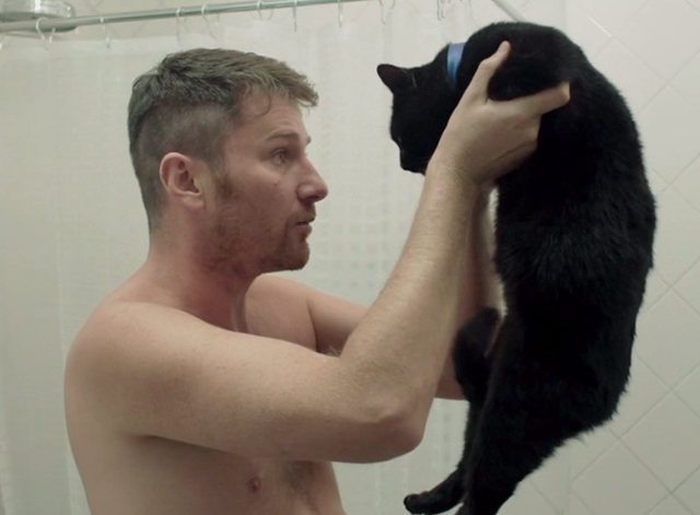Family Life - black cat Mississippi held up by Martin Jorge Becker in bathroom