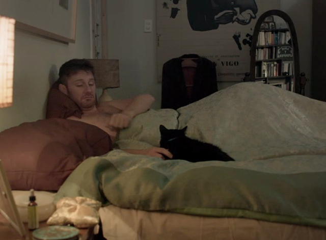 Family Life - black cat Mississippi lying on bed with Martin Jorge Becker
