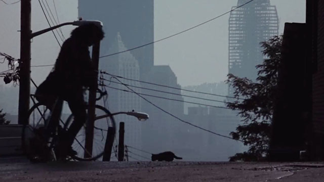 Flashdance - silhouette of Alex Jennifer Beals on bike approaching kitten on street