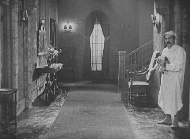Forgotten Sweeties - neighbor James Finlayson holding longhair tabby cat in corridor
