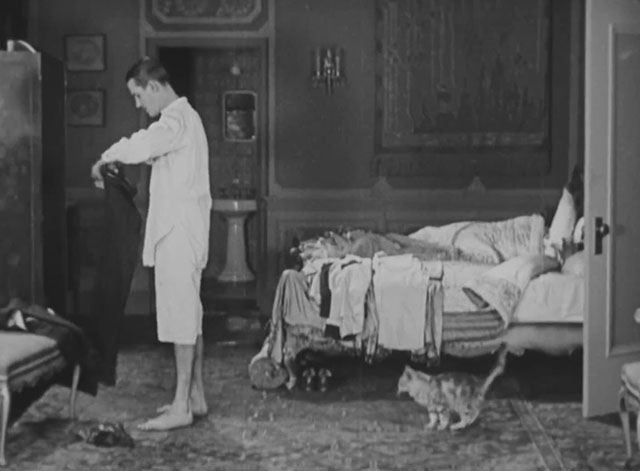 Forgotten Sweeties - Thurston Charley Chase with longhair tabby cat behind him in bedroom