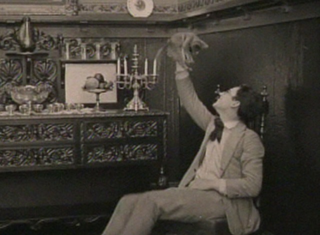 From Hand to Mouth - Harold Lloyd holds up gray kitten