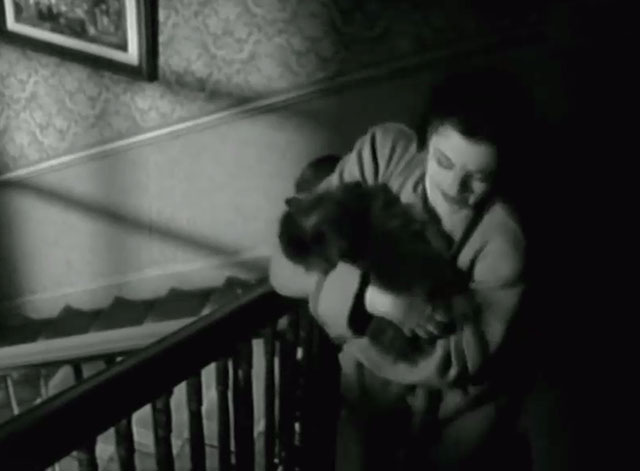 A Girl Must Live - Leslie Margaret Lockwood walking up stairs carrying gray Persian cat Jennie