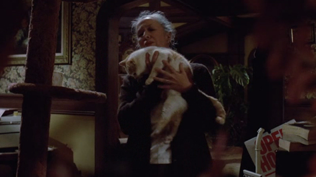 Gremlins - Mrs. Deagle Polly Holliday picking up orange and white cat Old Dollar Bill from cat tree