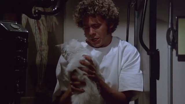 Gus - Andy Gary Grimes holding white cat behind X-ray machine