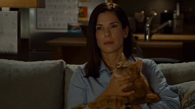 The Heat - Ashburn Sandra Bullock holding orange tabby cat Pumpkin on couch