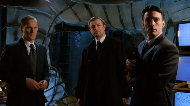 Hellboy - three agents, one of whom is holding a black cat