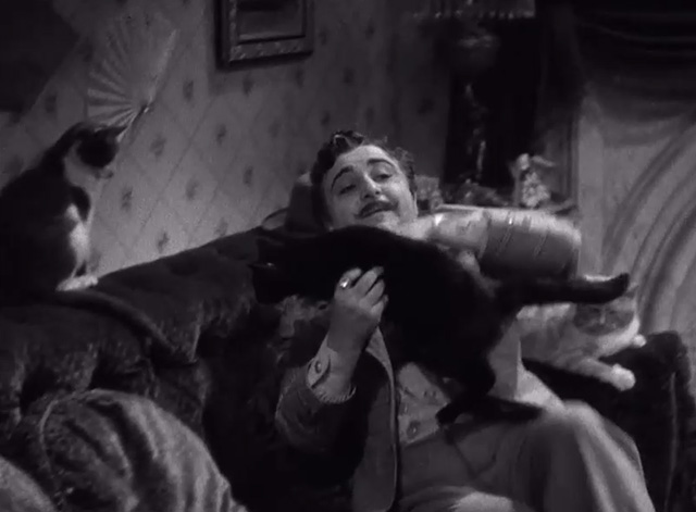 High, Wide and Handsome - Joe Varese Akim Tamiroff picking up black cat and lying on couch with tuxedo and tabby cats