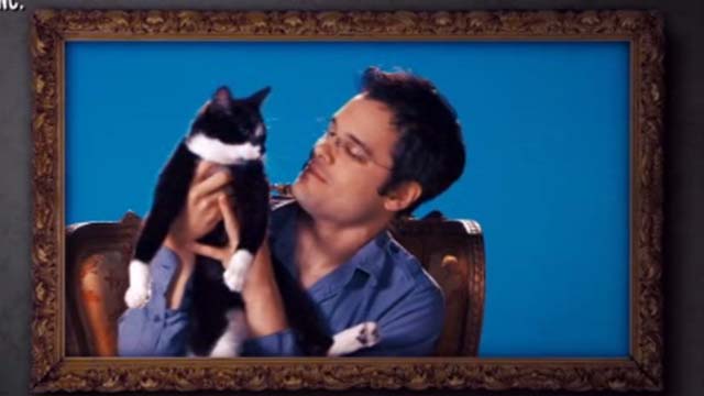 Hotel for Dogs - crew member looking at pet tuxedo cat