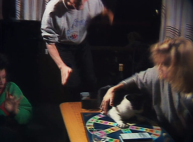 Houseboat Horror - brunette and blone woman playing Trivial Pursuit with tuxedo cat thrown onto board