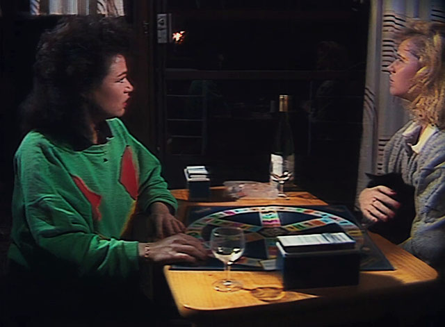Houseboat Horror - brunette and blone woman playing Trivial Pursuit with tuxedo cat in blonde's lap