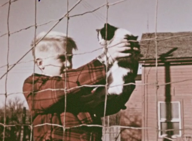How Animals Help Us - boy Jimmy holding up tuxedo kitten