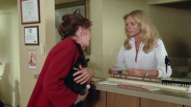 How to Beat the High Cost of Living - woman holding tortoiseshell cat at front desk