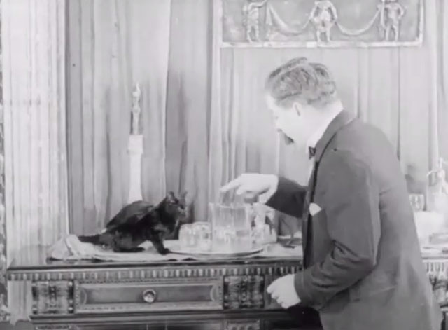 Hubby's Quiet Little Game - black cat drinking from glass on bar with Billy Foote Bevan