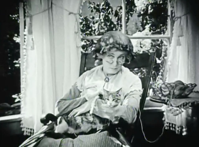 Huckleberry Finn - Aunt Polly Edythe Chapman sitting in chair with knitting and tabby and white cat on lap