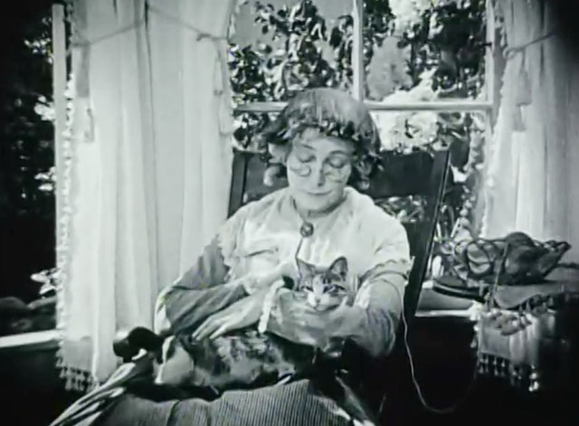 Huckleberry Finn - Aunt Polly Edythe Chapman sitting in chair with knitting and tabby and white cat on lap