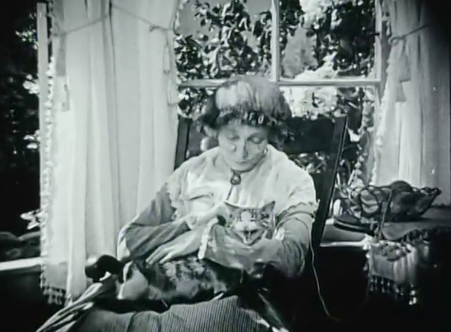 Huckleberry Finn - Aunt Polly Edythe Chapman sitting in chair with knitting and tabby and white cat on lap