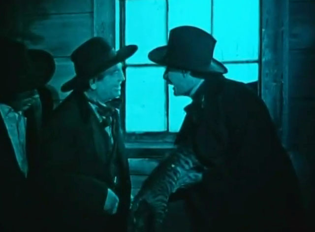 Huckleberry Finn - man holding deceased tabby cat in dark outside theatre