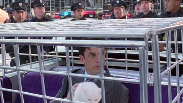Inspector Gadget - white cat Sniffy being held by Scolex Rupert Everett in cage in Gadgetmobile