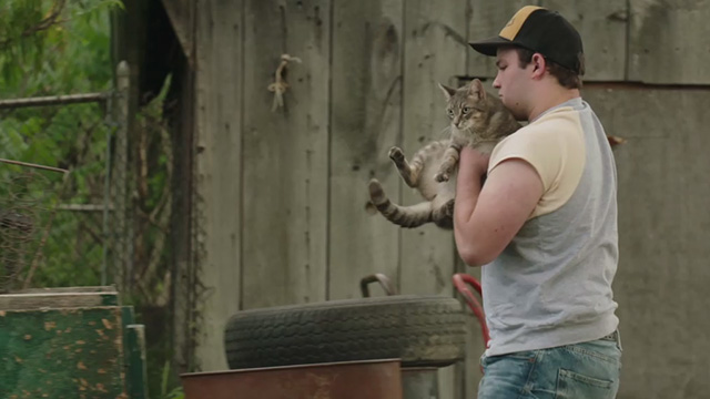 It - Belch Jake Sim picking up brown tabby cat