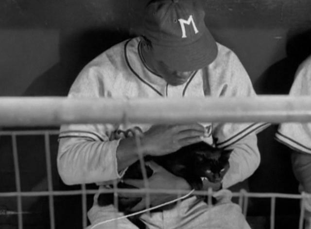 The Jackie Robinson Story - Jackie Robinson petting black cat in dugout