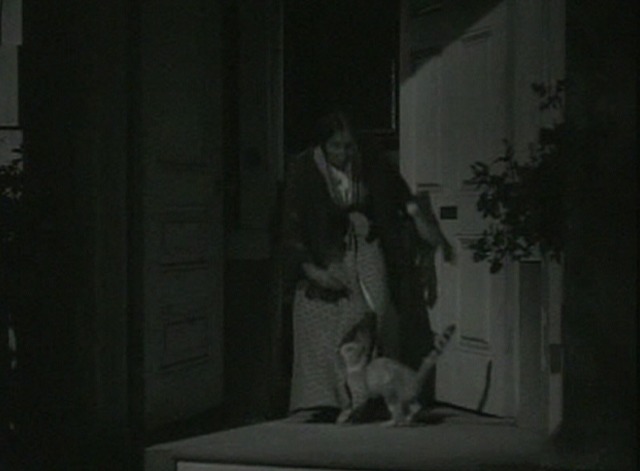 Journey for Margaret - women gathers up tabby cat from doorstep