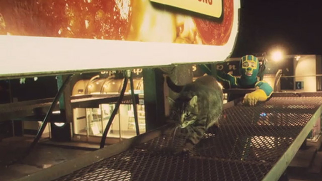 Kick-Ass - tabby cat Mr. Bitey on billboard catwalk with Kick-Ass Aaron Taylor-Johnson reaching for him