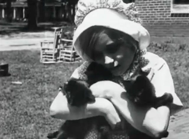 Kitty Kapers - little girl hugging three black kittens
