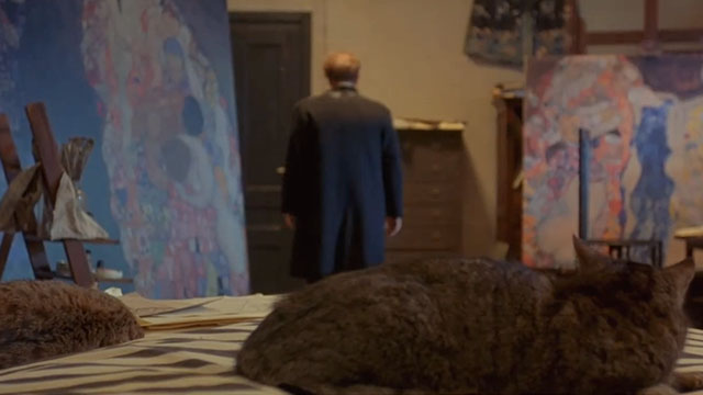 Klimt - John Malkovich walking away from bed with two brown tabby cats