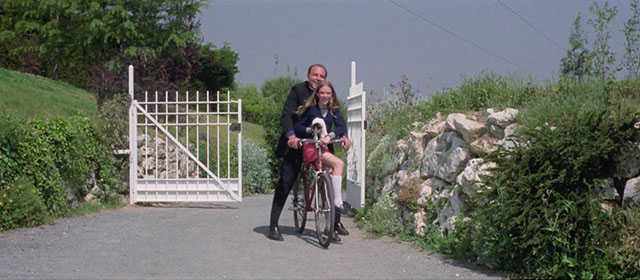Knife of Ice - Il coltello di ghiaccio - Christina Rosa M. Rodriguez arriving on bike with black and white kitten