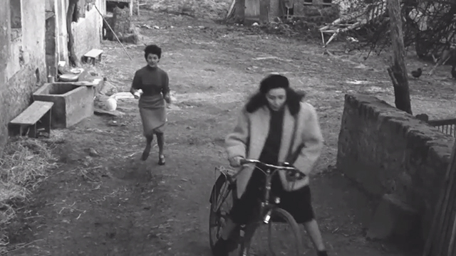 Léon Morin, Priest - Barny Emmanuelle Riva riding away on bike with Lucienne Gisèle Grimm chasing her and white cat nearby