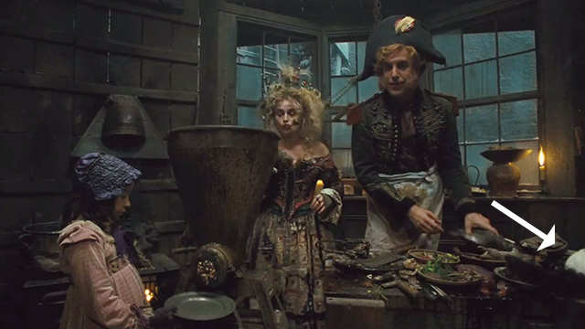Les Misérables - tuxedo cat on table with Thénardier Sacha Baron Cohen and wife Helena Bonham Carter