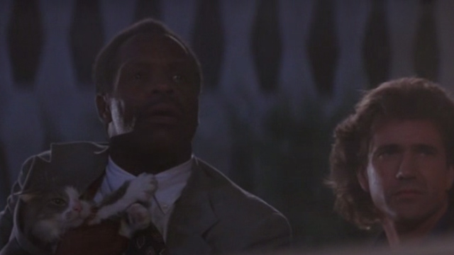 Lethal Weapon 3 - Murtaugh Danny Glover and Riggs Mel Gibson looking from behind car with cat